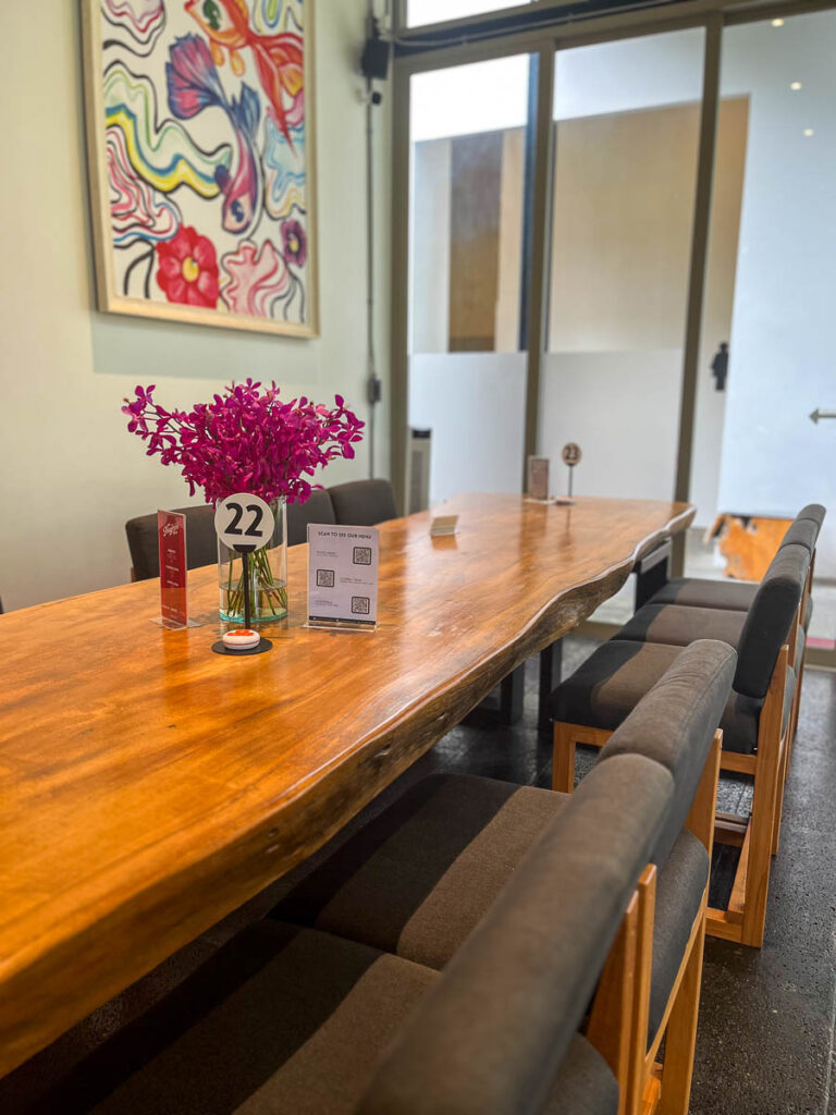An impressive single-piece wooden table located at the rear of Vaanaa