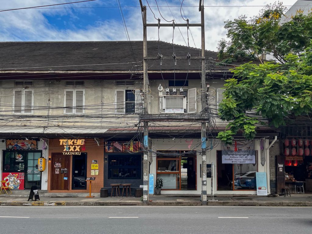 The 'secret' entrance to Building A, beneath a tangle of overhead wires on Charoen Mueang Road