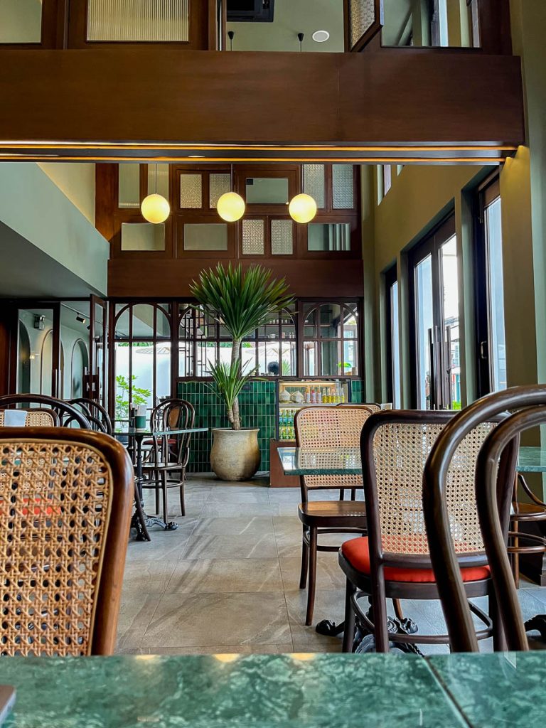 Wood tones, rattan chairs, and jungle-green tiles—brunch in style at Kati Breakfast & Brunch