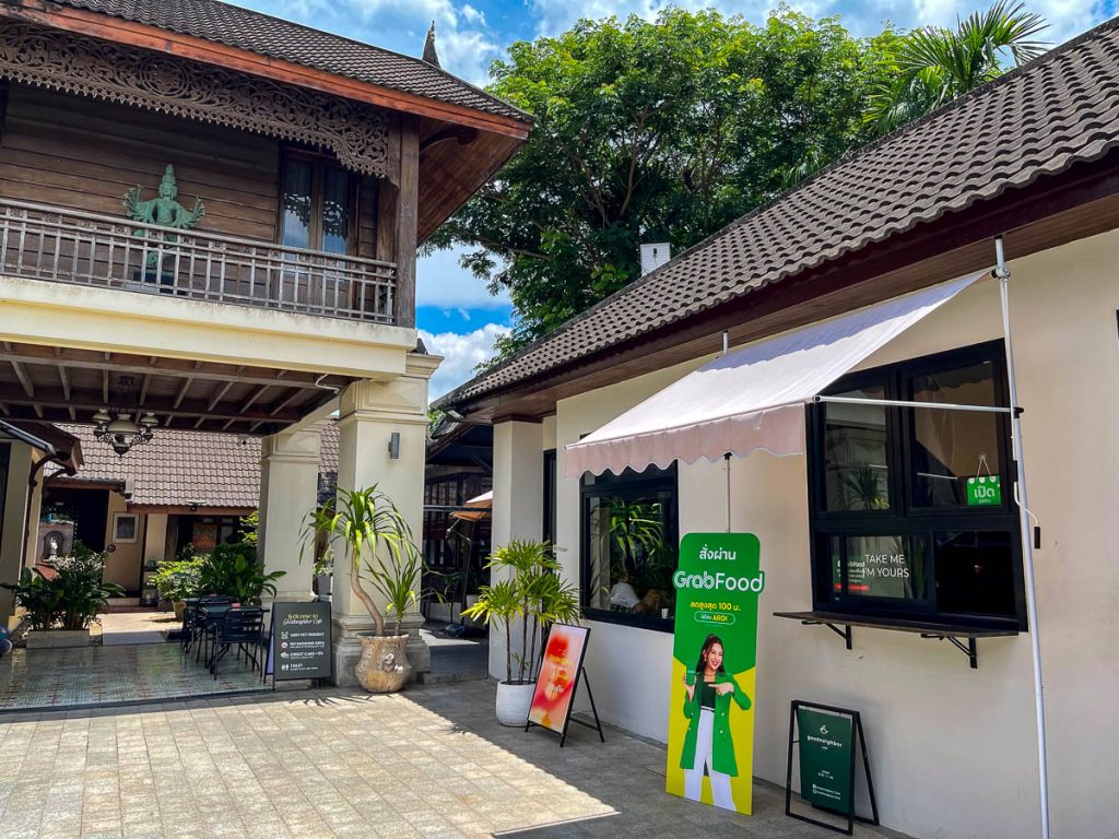 Goodneighbor's modest white cafe (right) shares its outdoor space with an elegant Thai dwelling