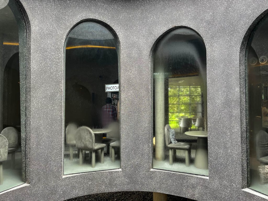 Where concrete meets cosmos—PLUTO’s sculptural stairwell and central skylight, framed by window arches