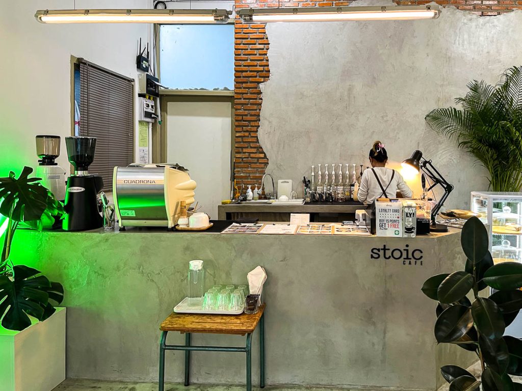 The concrete counter at Stoic Cafe, softened by greenery and warm light—minimalist design with character
