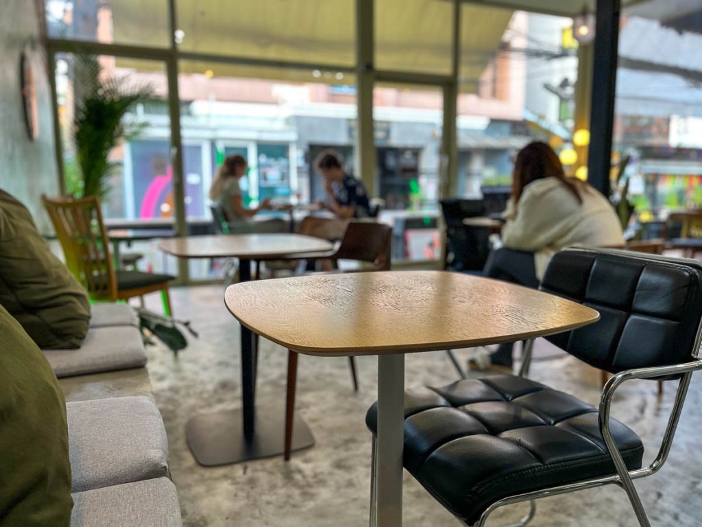 Interior of Stoic Cafe Chiang Mai showing industrial design, concrete seating, leather chairs and floor-to-ceiling windows