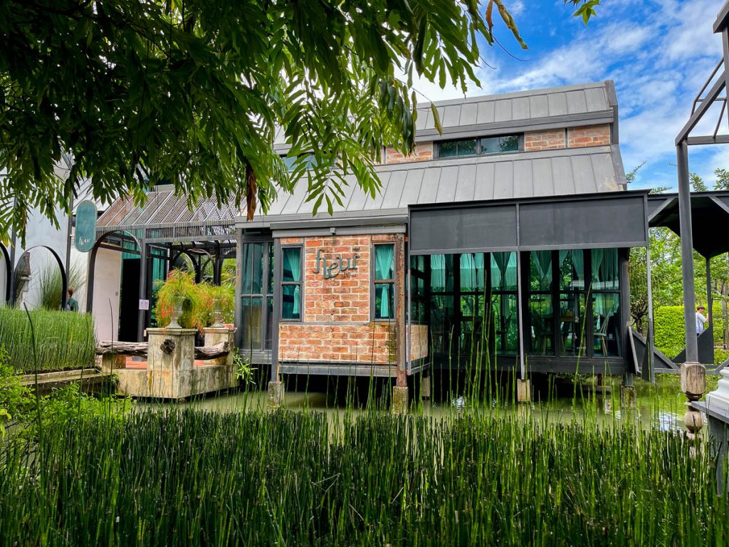 One of Fleur Cafe’s striking restaurant buildings seems to float serenely above the pond