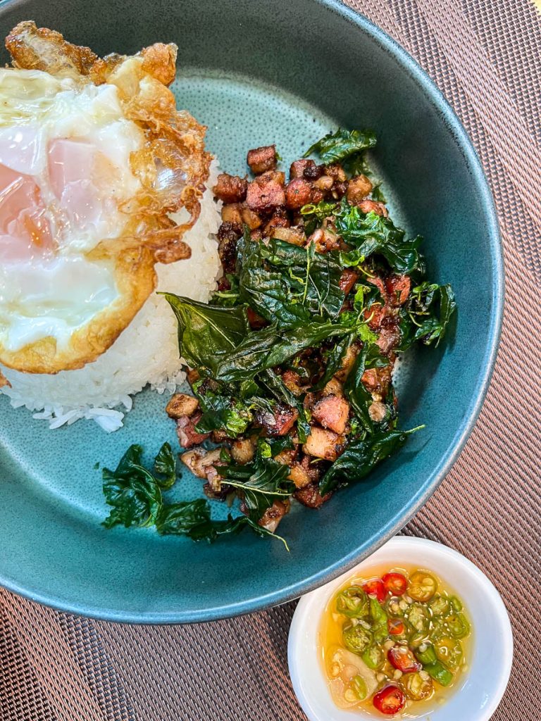 Smoky, spicy, and crowned with a golden fried egg—Fleur Cafe’s wood-smoked pork Pad Kra Prao is a standout