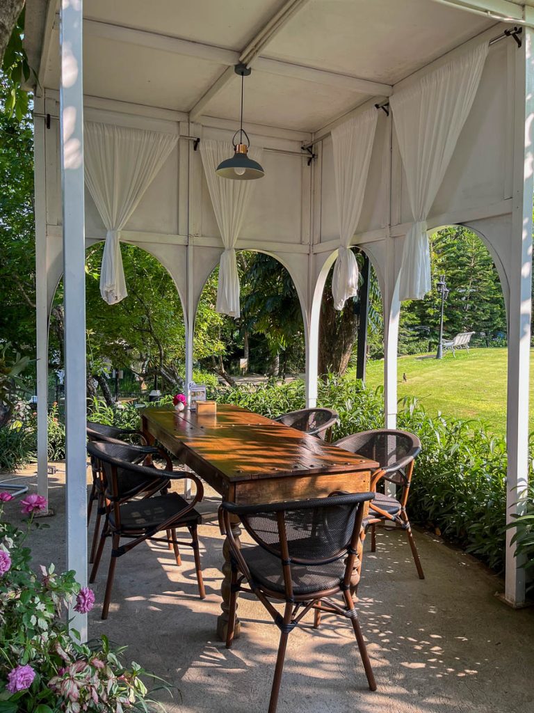 White drapes, wooden tables, and roses at your feet—Alfresco dining with a touch of romance at Fleur Cafe
