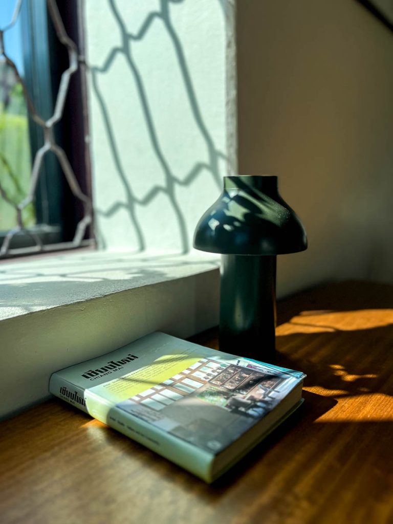 A Chiang Mai guidebook dappled with sunlight from a lattice window at Baan 104