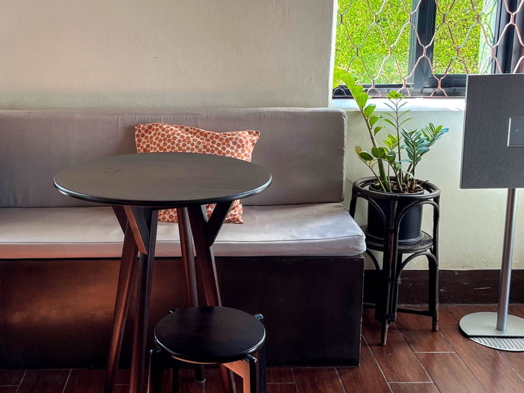 Interior seating at Baan 104 cafe Chiang Mai with cushioned bench seats, warm lighting and heritage-style wooden interiors