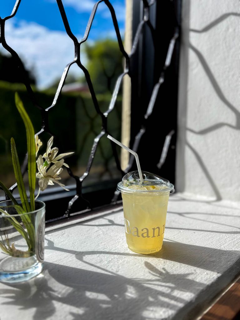 Refreshing honey lemon drink served by the window with patterned shadows inside The Pantry at Baan 104
