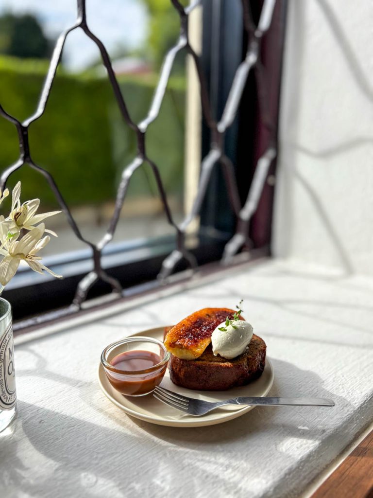 Banana toast with caramel sauce and whipped cream served by the window at The Pantry in Baan 104, Chiang Mai.