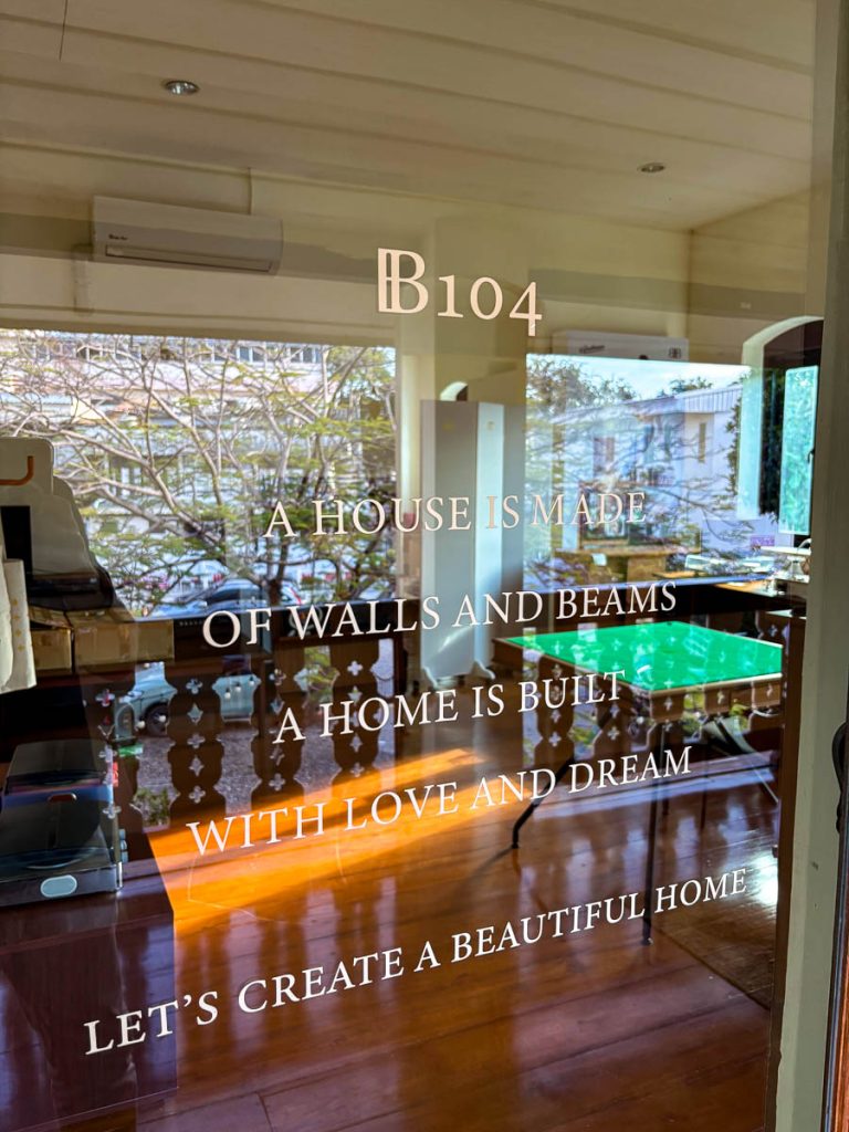 A glass door with etched message and view into B104, upstairs at Baan 104