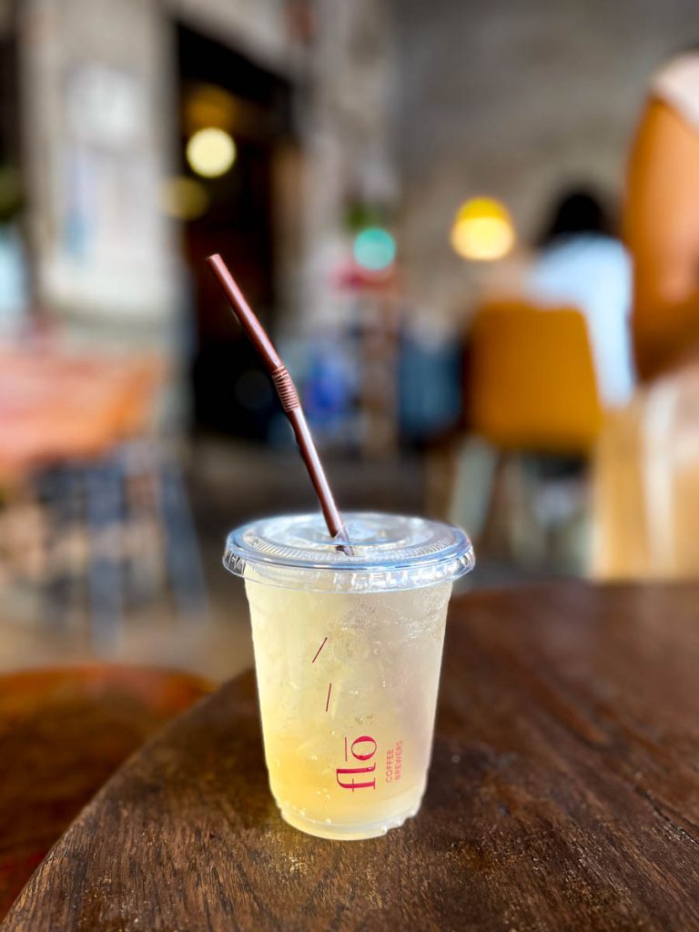 Cold soda drink on a wooden table inside Flo Coffee Brewers, a speciality coffee shop in San Pa Khoi, Chiang Mai