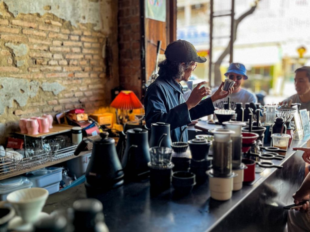 Barista preparing pour-over coffee at the slow bar inside Flo Coffee Brewers in Chiang Mai