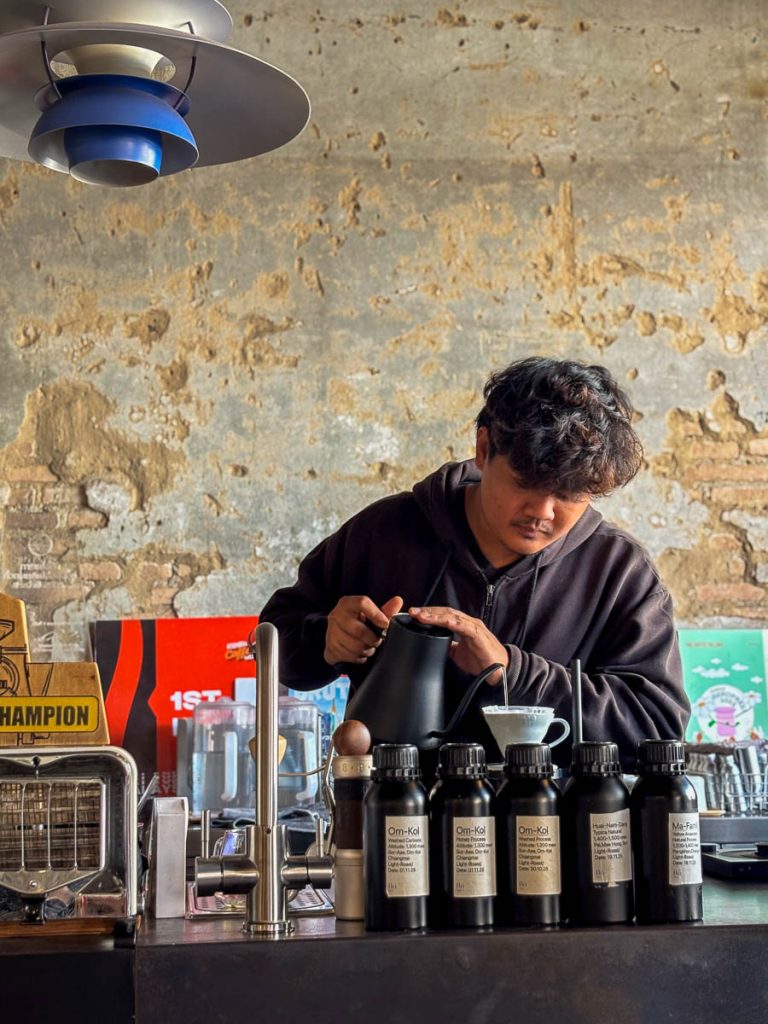 Barista preparing hand-brewed coffee at the slow bar inside Flo Coffee Brewers in San Pa Khoi, Chiang Mai