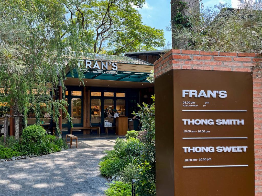 Fran’s Chiang Mai exterior showing brick signage wall and leafy garden pathway