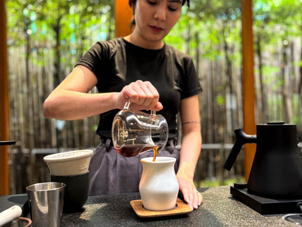 Barista pouring specialty slow bar coffee into ceramic cup at Baristro Asian Style Chiang Mai