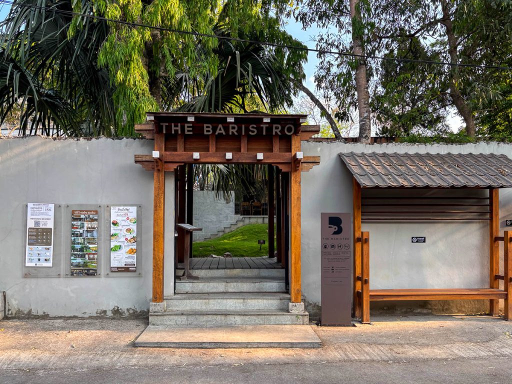 Street entrance of Baristro Asian Style Chiang Mai with wooden gate archway and THE BARISTRO sign