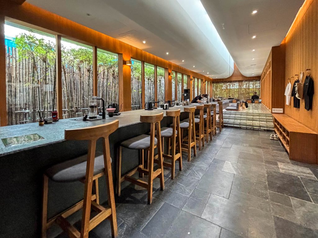 Coffee slow bar at Baristro Asian Style Chiang Mai with high timber stools, stone counter and bamboo windows