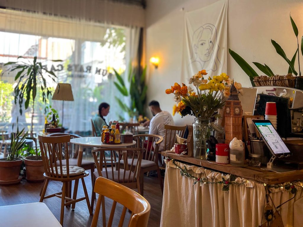 Quiet seating corner inside Sun Rays Cafe Chiang Mai with wooden floors, soft lighting and cosy vintage-style interior