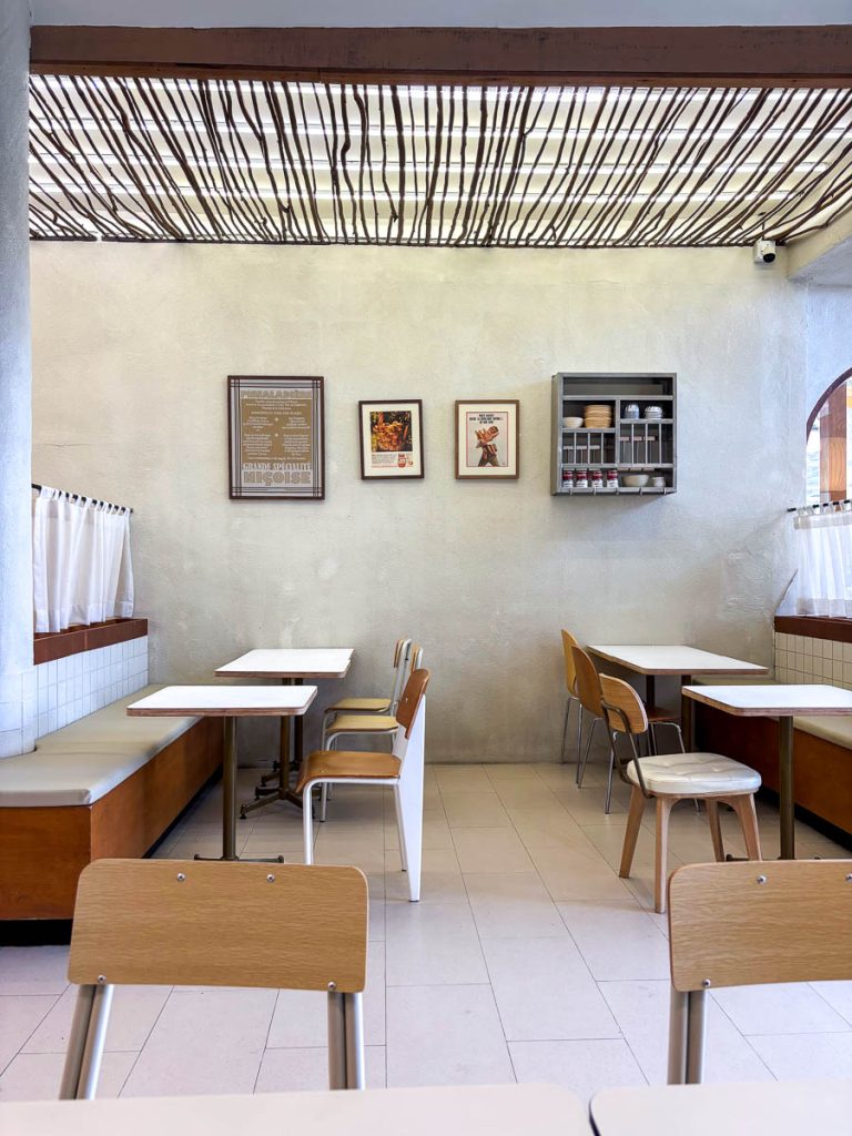 Interior seating area at GROON Bread & Brunch Cafe in Nimman, with warm wood furnishings, textured walls, and contemporary Mediterranean-inspired design