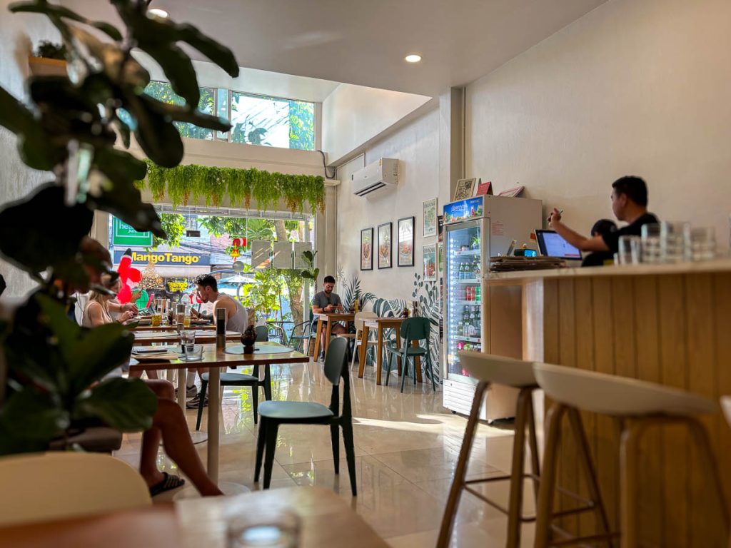 Interior of Healthy Junk in Nimman, Chiang Mai, with minimalist decor and warm wooden tables
