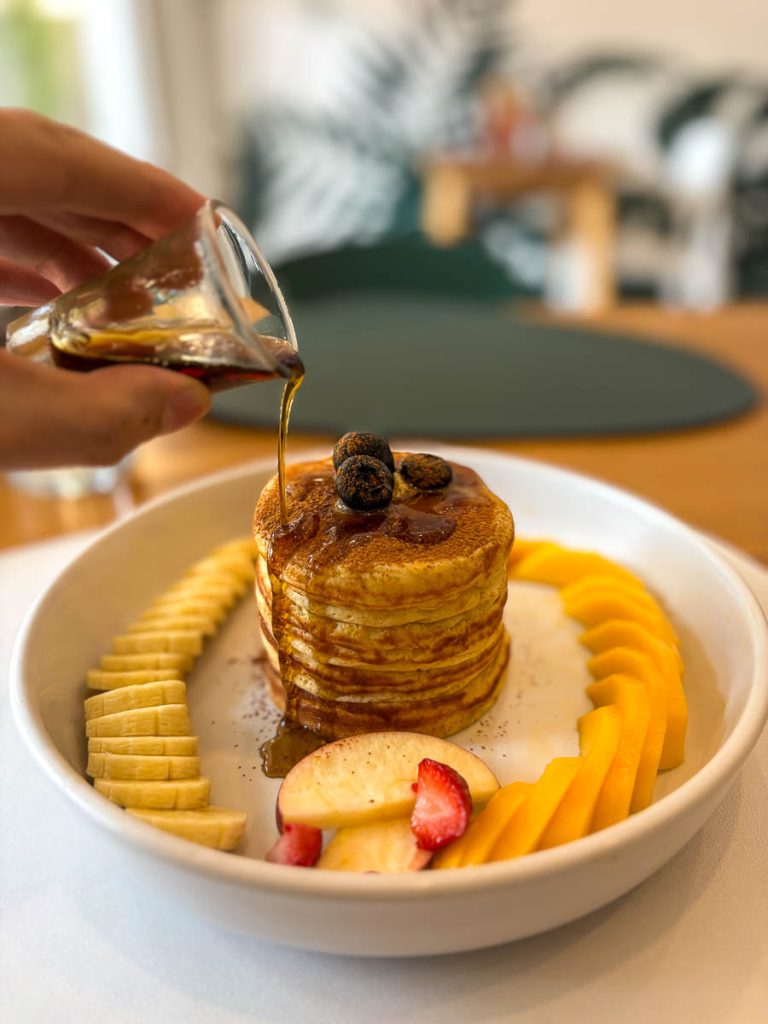 Healthy Junk gluten-free pancake served with banana, mango and seasonal fruit