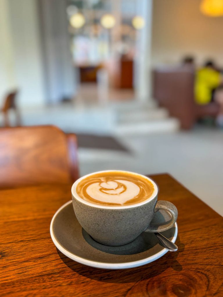 Bays Coffee hot latte in a grey cup at Food4Thought East, 113 Compound, Chiang Mai