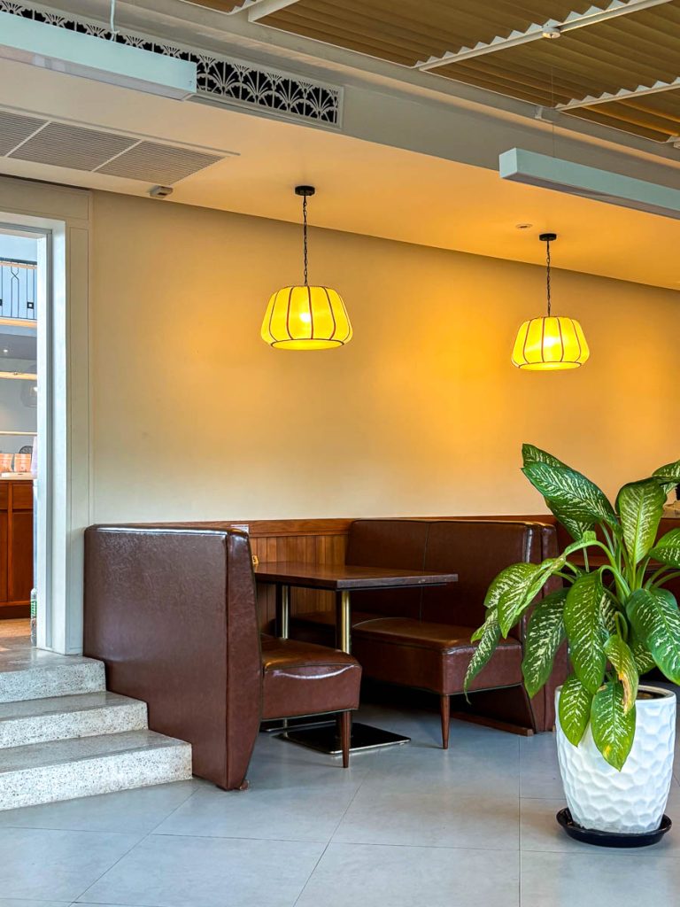 Leather booth seating under amber pendant lanterns at Food4Thought East, Chiang Mai