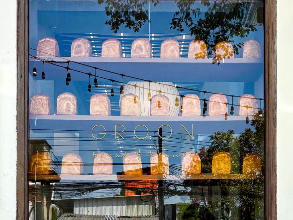Bread display in the front window of GROON Bread & Brunch Cafe in Chiang Mai, showcasing the cafe's bakery-focused concept